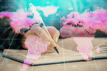 International business hologram over hands taking notes background. Concept of success. Multi exposure