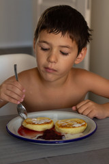little boy eating breakfast at the table