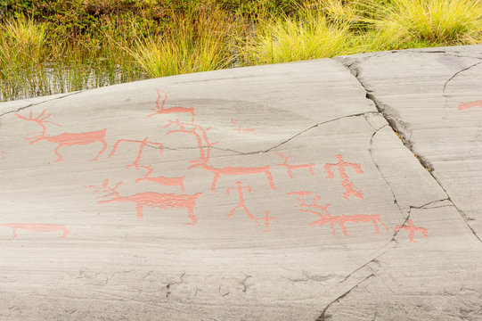 Rock art in Alta Fjord, Norway. Ancient symbols, real drawing,  texture in stone. Red ocher paint. Human preys on animals deer.  Group of petroglyphs, dating from c. 4200 to 500 B.C.