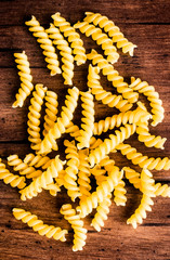 Uncooked whole wheat fusilli italian pasta background, selective focus. Pasta pattern. Food background. 