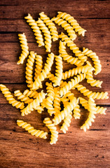 Uncooked whole wheat fusilli italian pasta background, selective focus. Pasta pattern. Food background. 