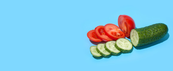 Ripe green cucumber and red tomato on blue background. Healthy eating and dieting concept.. Copy space. Free space for your text