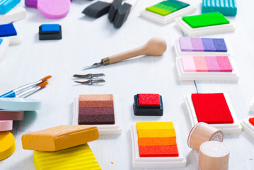 ink pads, brushes and carving cutters on white wood table