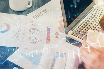 Double exposure of man's hands writing notes of stock market with forex graph background. Concept of research and trading.