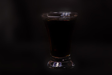 Glass of whiskey with splash on black background
