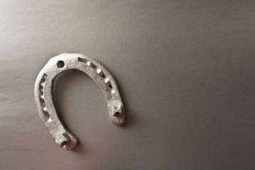 Silver horseshoe on a gray background. An old horseshoe. Close up.