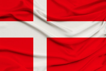 Denmark flag on silk fabric background with waves and drapery. Background for design, close-up, copy space