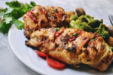 Fried chicken fillet. Broccoli and cauliflower. Baked chicken breast. Chicken and tomato. Food in a white plate on a light table background.