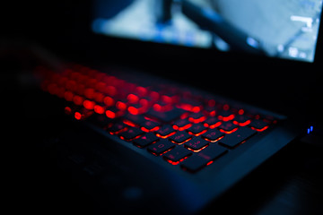 Red backlit keyboard close up. Gaming laptop.