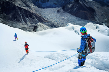 Group of climber descending after mountain summit peak enjoying the landscape view.