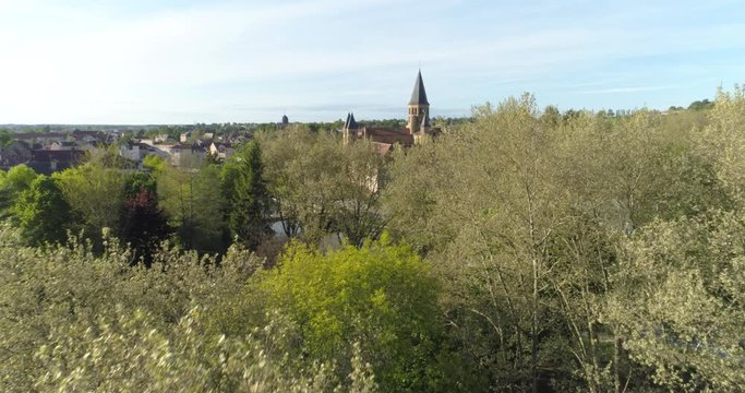 Paray-le-Monial basilica appearing behind trees, France