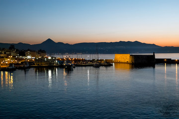  View of the fortress and ships in the port of Heraklion at sunset