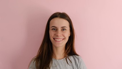 Positive european woman makes okay gesture, wears gray T-shirt, enjoys life, isolated over pink background, says ok, confirms information. Its excellent result