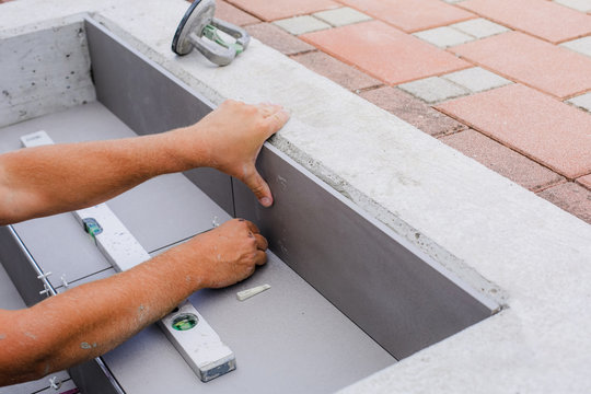 Tiler hands working on a new house entrance, local and professional handyman applying tiles to the steps.