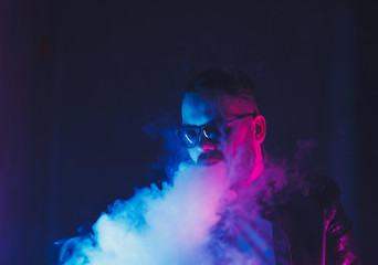 bearded man smoking vape and wearing sunglasses in a nightclub