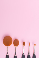 Set of oval brushes for makeup on pink background