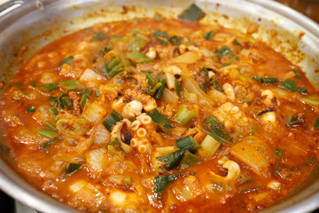 A close-up view of a spicy and hot cuisine with various sea food ingredients such as shrimp, small octopus, and tripe.