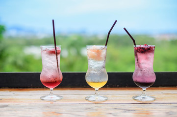 three exotic cocktails in good view ; fresh summer cold alcohol drinks