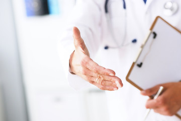 Male medicine doctor hold pad and give arm to shake in office closeup. Friend welcome introduction...
