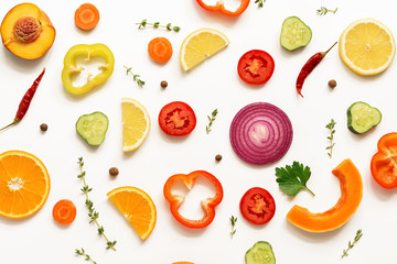 Flat lay slices of vegetables and fruits on a white background, isolated. View from above