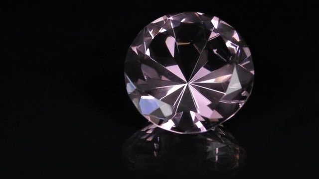 Slider shot, large pink rhinestone on a black background. Beautiful light reflection.