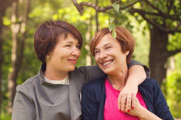 Fototapeta premium Two happy women walking in summer park, portrait