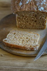 Selbst gebackenes Brot mit einer geschnittenen Scheibe im Vordergrund