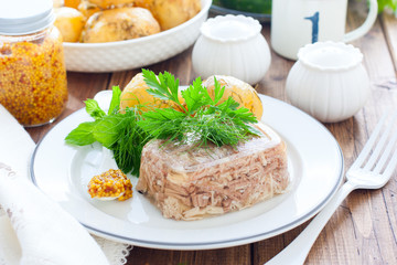Homemade Aspic of turkey meat on a white plate with boiled potatoes, horizontal