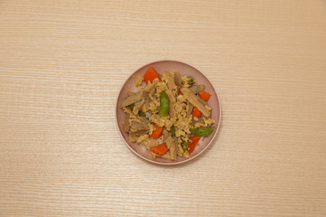 Japanese healthy donburi meal (butadon) made with rice, pork, green beans, carrot and burdock. Background with wood table.