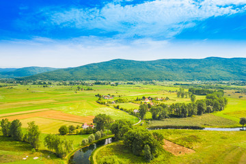Croatia, countryside landscape, small village by Gacka river in region of Lika, aerial view