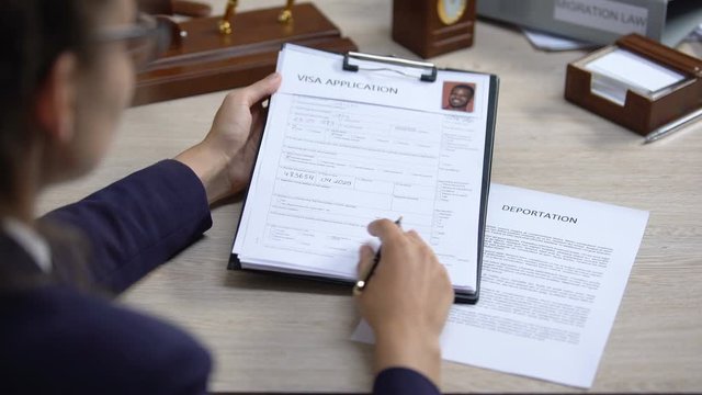 Woman suit analyzing visa application and signing deportation, migration rules