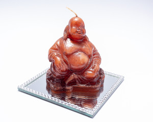 Buddha shaped candle on mirror. Isolated on white background.