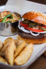 Tasty Hamburger with beef meat, potatoes, salad, tomato and onion