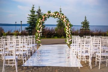 Outdoor wedding ceremony place with wedding arch