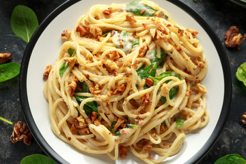 Pasta with roasted walnut, ricotta white pesto sauce, parmesan cheese and spinach