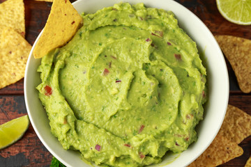 Bowl of fresh Guacamole with nachos chips and herbs. Healthy Vegan, Vegetables food.