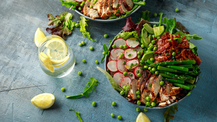 Cobb salad bowl with grilled chicken breast, asparagus, avocado, radishes and bacon