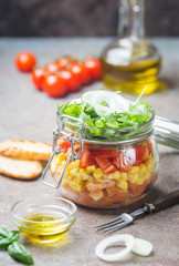 Healthy Homemade Mason Jar Vegetables Salad with tomatoes, corn, pepper, arugula and onion