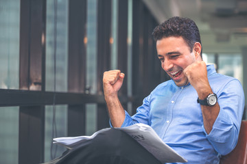 Businessman reading newspaper over office building. Businessman happy smiling after reading goods news. Man goot a new job.