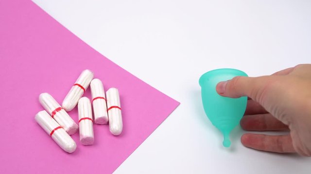 the female hand chooses the menstrual cup as an alternative to hygienic tampons, personal care products during menstruation period time