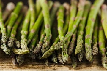 Freshly picked organic asparagus tips on wooden board