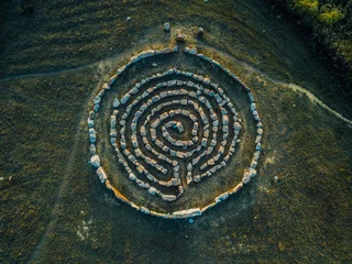 Schilderijen op glas Spiral labyrinth made of stones, top view from drone © Mulderphoto