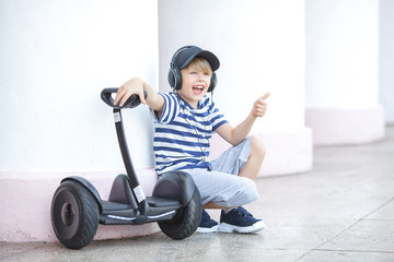 Cute little boy driving segway. Child skating on hyroboard. Boy driving hover.