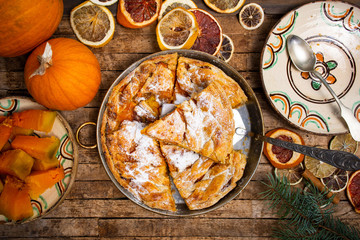Homemade pumpkin pie with various ingredients