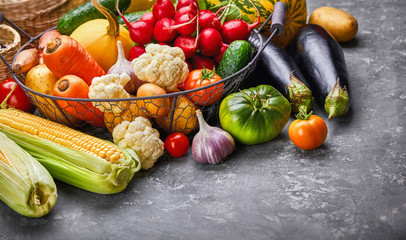 Harvest vegetables with herb kitchen garden on grey concrete surface top view. Healthy food and vegan food still life garden inventory.