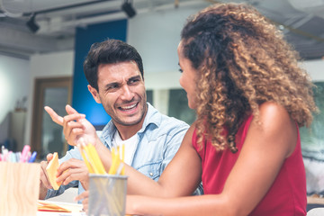 Young businessman and businesswoman in casual clothes having a new project discussion or having an idea at workplace.