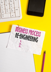 Text sign showing Business Process Re Engineering. Business photo text the analysis and design of workflows Crumpled white paper on table with paper clips clock mobile and pc keyboard