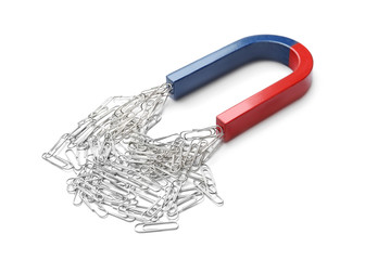 Magnet attracting paper clips on white background
