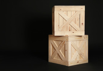 Wooden crates on black background. Space for text