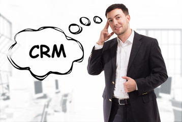 Business, technology, internet and network concept. The young businessman comes up with the keyword: CRM